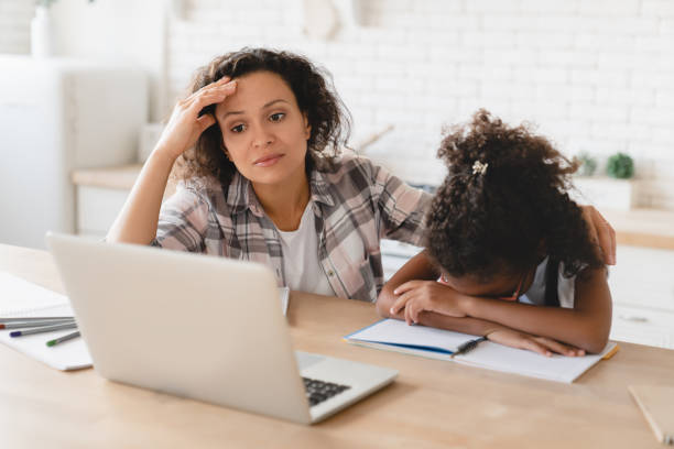 istock School problems. Homeschooling. African-american mother helping assisting daughter with homework, school load. Tutor explaining hard difficult task to a student with laptop. Distant e-learning 1368393863