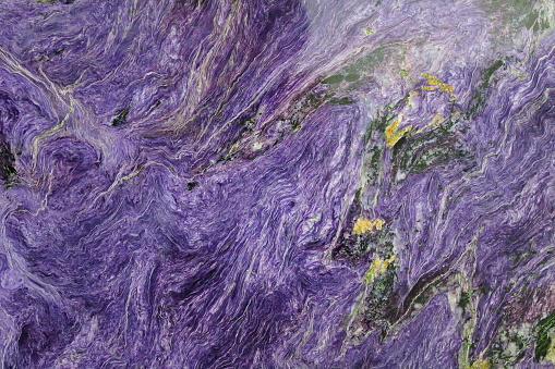 Charoite stone in the cut. Close-up. Background. Texture.