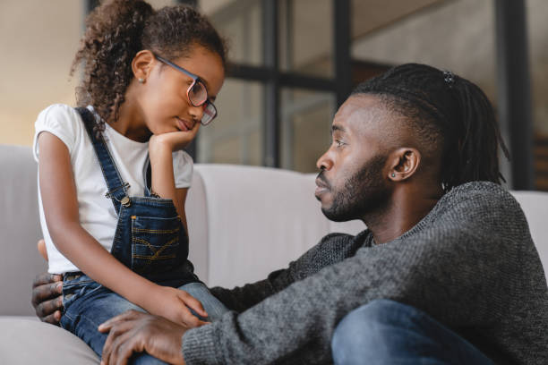 istock Loving african-american father dad listening to daughter`s problems with attention, supporting and calming her at home. Solving family problems. Fatherhood. 1368394124