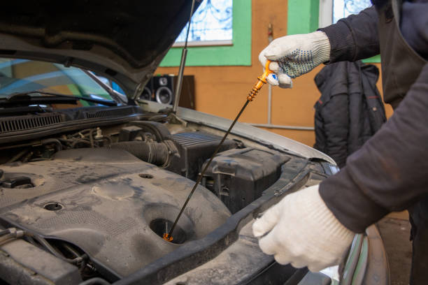istock Car mechanic checking oil level in a mechanical workshop. 1368394130