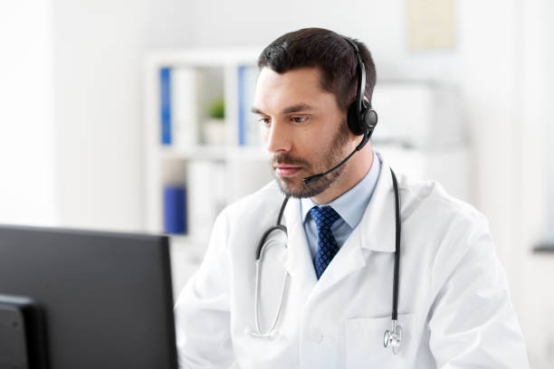 istock male doctor with computer and headset at hospital 1368395931
