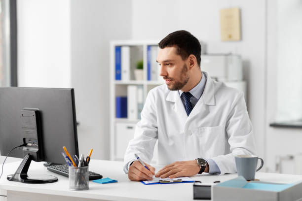 istock doctor with clipboard and computer at hospital 1368396107