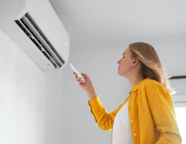 Women dying from the heat standing in front of the air conditioner. Women dying from the heat standing in front of the air conditioner. air conditioner stock pictures, royalty-free photos & images