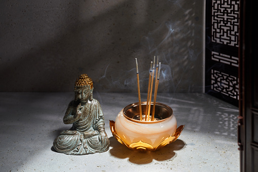 Burning aromatic incense sticks. Incense for praying Buddha. Zen background.