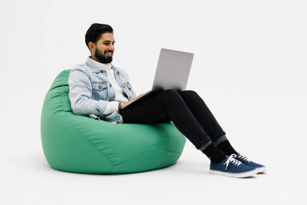 istock Young man holding notebook browsing chatting colleagues sitting comfy soft armchair wear specs casual denim outfit isolated grey color background 1368397767