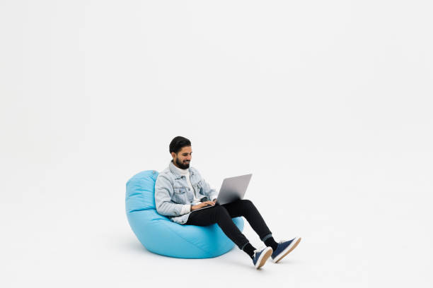 istock Young man holding notebook browsing chatting colleagues sitting comfy soft armchair wear specs casual denim outfit isolated grey color background 1368398081