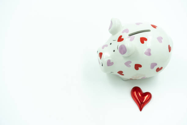 White piggy bank with red heart on white background. stock photo