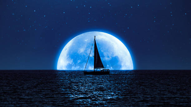 полная луна и милки путь, возвышающийся над океанским морским горизонтом с силуэтом парусной лодки. - nautical vessel фотографии стоковые фото и изображения