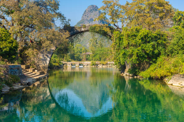 Karst landscape of Guilin, China The Fuli Bridge on the Yulong River in Yangshuo, Guilin, China li river stock pictures, royalty-free photos & images