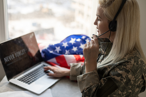 military man using laptop with veterans day screen.