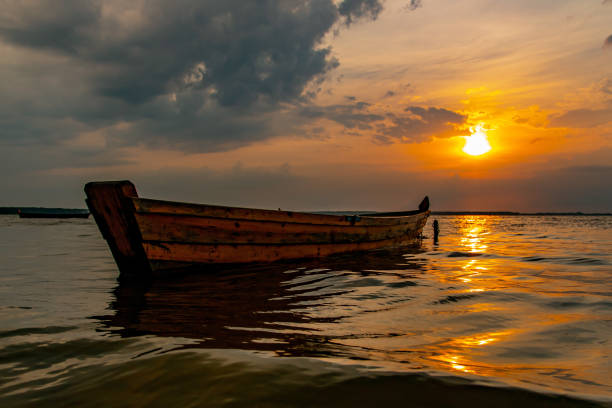 istock Single Boat on Lake at Summer Sunset 1368401158
