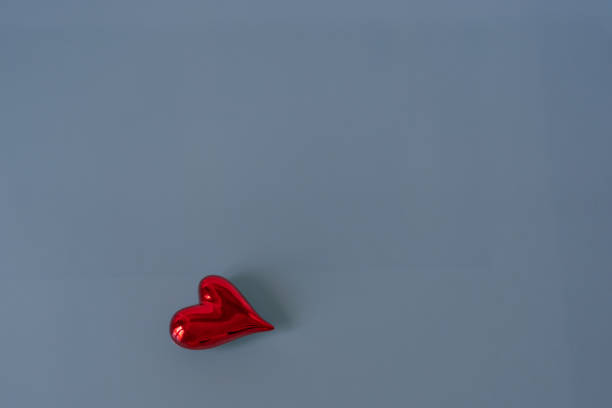 istock Isolated red shiny heart on blue glass background. 1368403478