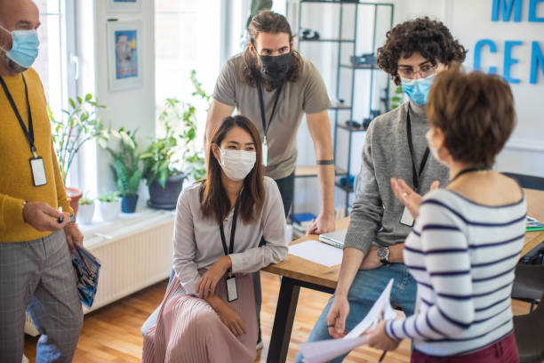 istock While wearing prtoective face mask, multiracial journalists and editors talking at the office 1368403480