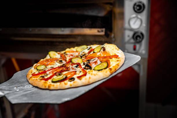 istock chef baker making pizza at kitchen. Put on landing shovel and send it to the oven. 1368406368