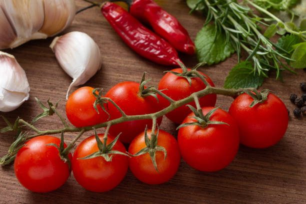 istock Tomatoes, garlic, peppers and herbs over wood table 1368406654