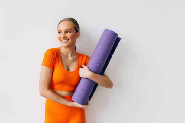 istock Fit woman with a gym mat isolated over white background 1368407322