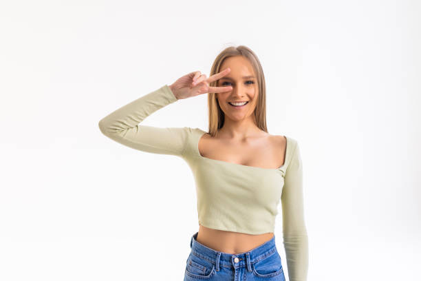 istock Happy young woman showing peace sign with both hands over white background 1368408843