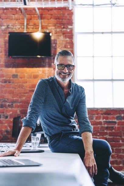 istock Experienced businessman smiling at the camera in an office 1368408877
