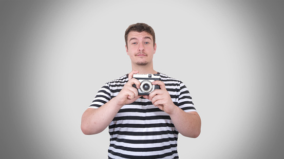 A young man holding an analog camera