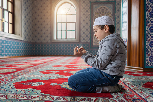 Cute little muslim boy praying in Mosque
