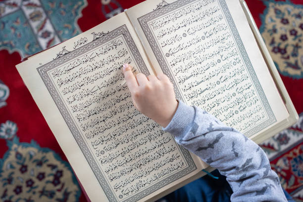 istock Close up boy hand reading The Holy Koran 1368409580