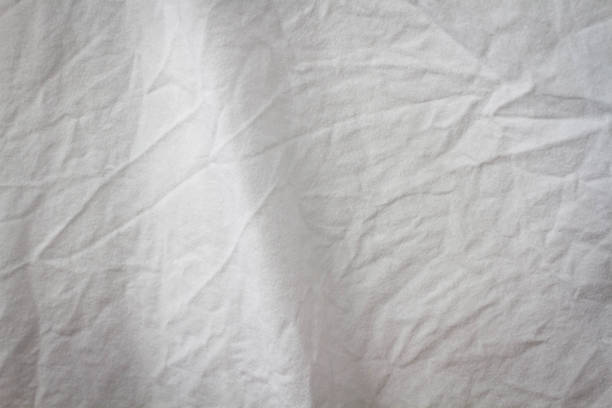 istock Wrinkled sheet. White fabric close-up. Burlap texture. Sheet on the bed. 1368410750