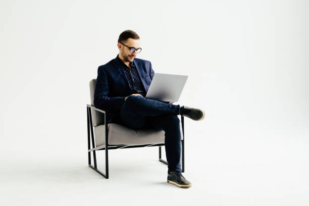 istock Smiling handsome businessman working with laptop over white background 1368411984