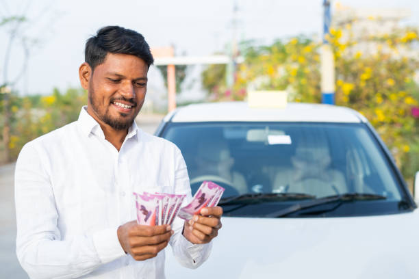 happy smiling cab driver counting money in front of car - concept of profit business, loan approval, financial, banking and self employment. - india car people business imagens e fotografias de stock