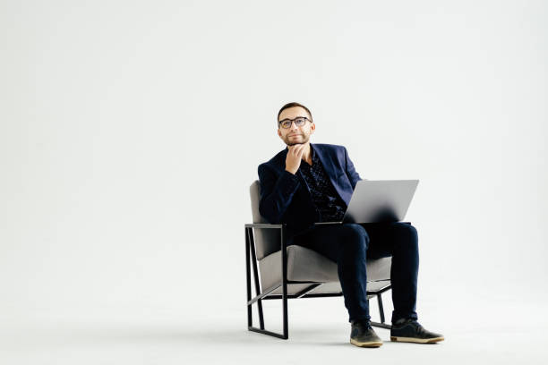 istock Smiling handsome businessman working with laptop over white background 1368412106