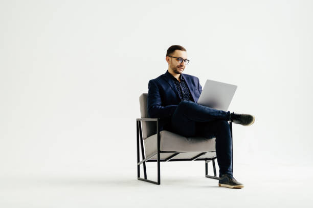 istock Pleasant positive business man using laptop on white background 1368412358