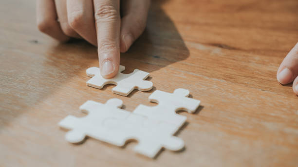 istock Business man hands connecting jigsaw puzzle. Business solutions, success and strategy concept. 1368412556