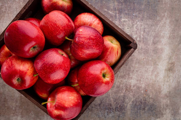 istock Ripe red apples in wooden box. Top view with space for your text. 1368412962