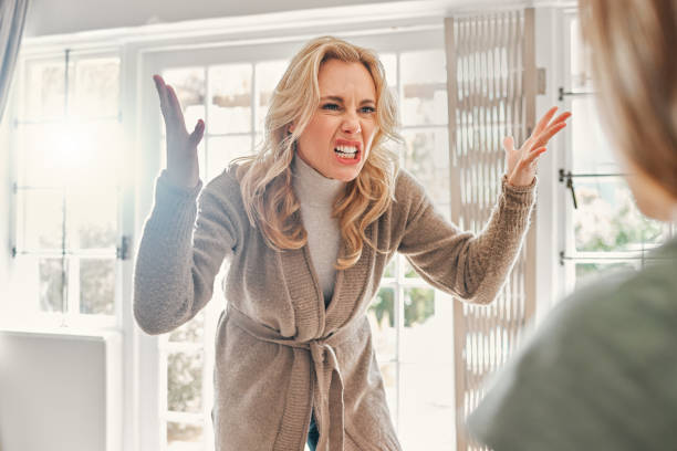 Shot of a mature woman looking upset while scolding someone at home Heal yourself so you don't project onto others 12 13 years pre adolescent child female blond hair stock pictures, royalty-free photos & images