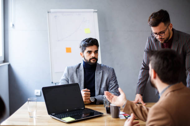 istock Teamwork. Three young colleagues are talking in the office, working. 1368414706