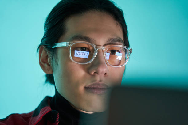 istock Concentrated asian man sitting at the prohibited sites using laptop and getting virus 1368416044