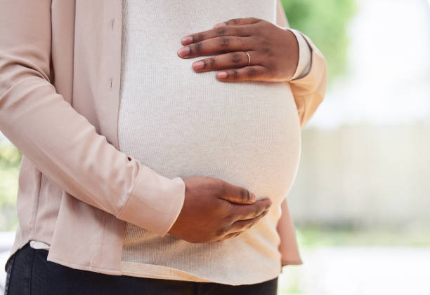 scatto ritagliato di una madre irriconoscibile per essere in piedi nel suo salotto di casa - pregnancy foto e immagini stock