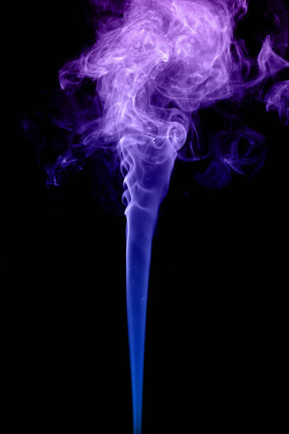 istock Clouds of curls of colored smoke on a black background. 1368421086