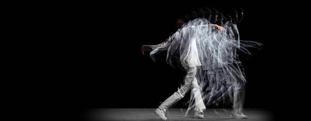 Young man, hip-hop dancer in action, motion isolated on dark background with sroboscope effect. Youth culture, hip-hop, movement, style and fashion, action.