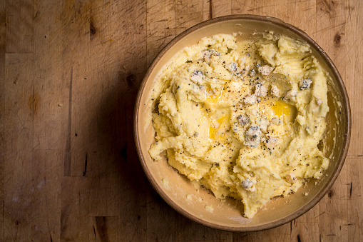 Stock photo of a rustic bowl filled with buttery mashed potatoes
