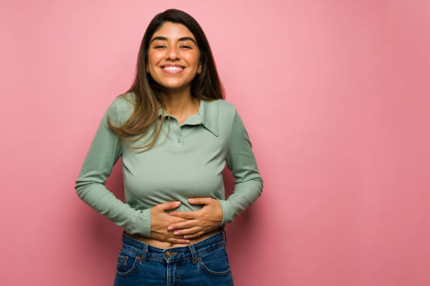 gut gelaunte frau nach dem essen - abdomen stock-fotos und bilder