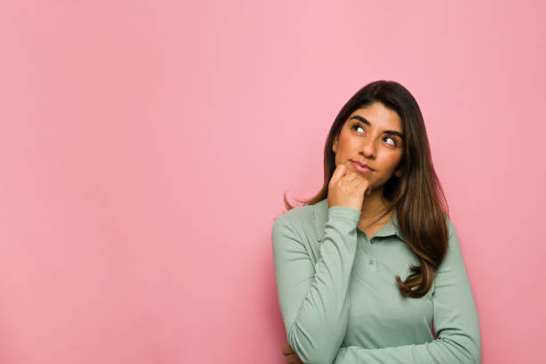 Smart young woman dreaming Thoughtful woman thinking about a new idea and the future while using her imagination daydreaming stock pictures, royalty-free photos & images