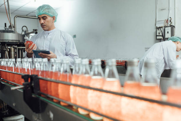 istock workers in factory checking products. workers inspecting production line at drinks production factory. working Concept 1368429075