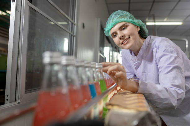 istock workers in factory checking products. workers inspecting production line at drinks production factory. working Concept 1368429200