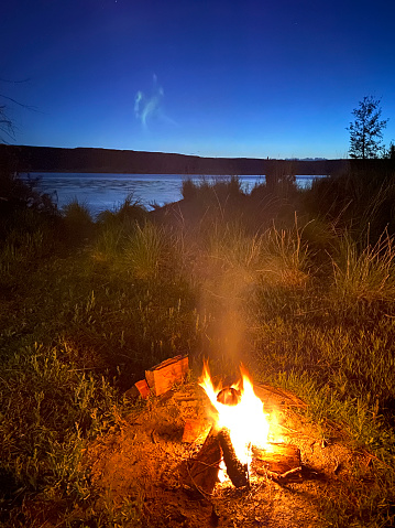 Campfire glowing at night while camping in the desert in Grand Coulee, Washington, United States