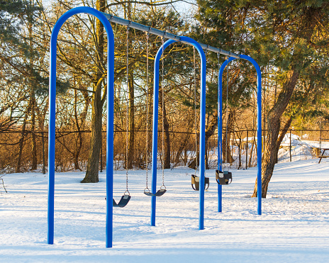 Children's swings with park with snow in Port Colborne, Ontario, Canada