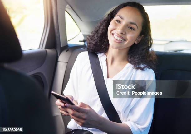 Cropped Shot Of An Attractive Young Businesswoman Sending A Text While Sitting In The Backseat Of A Taxi Stock Photo - Download Image Now