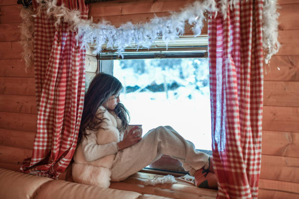 istock Female Child Falling Asleep By Cottage Window While Drinking Tea And Watching Snow Fall 1368432411