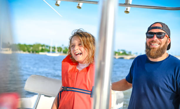 Family boat day, father and young daughter in life jacket on a speed boat enjoying a day on the water Family boat day family motorboat stock pictures, royalty-free photos & images