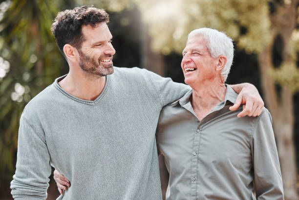 shot of a man standing outside with his elderly father - zoon stockfoto's en -beelden