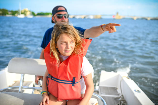 Family boat day, father and young daughter in life jacket on a speed boat enjoying a day on the water Family boat day family motorboat stock pictures, royalty-free photos & images